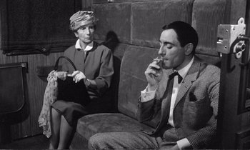 Movie still from “Yoyo” (1965), directed by Pierre Étaix – An older woman sitting next to an older man on a couch; Medium shot, High angle