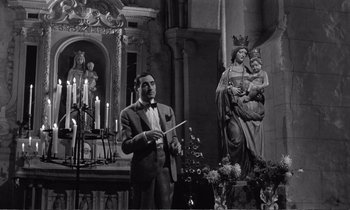 Movie still from “Yoyo” (1965), directed by Pierre Étaix – A black and white photo of a man in a suit holding a sword; Medium shot, Low angle