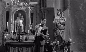 Movie still from “Yoyo” (1965), directed by Pierre Étaix – A black and white photo of a man and a statue; Medium shot, Low angle