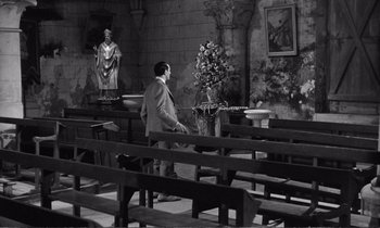 Movie still from “Yoyo” (1965), directed by Pierre Étaix – A man standing in front of a bunch of benches; Wide shot, High angle