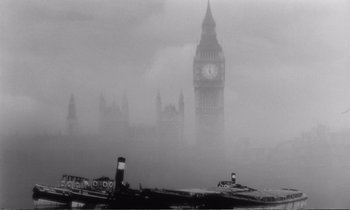 Movie still from “Yoyo” (1965), directed by Pierre Étaix – A boat in the middle of a river with a clock tower in the background; Extreme Wide shot, Low angle