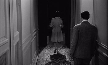 Movie still from “Yoyo” (1965), directed by Pierre Étaix – A man and a woman walking down a hall way; Wide shot, Over the shoulder angle