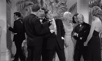 Movie still from “Yoyo” (1965), directed by Pierre Étaix – A black and white photo of a group of people in formal wear; Wide shot, High angle