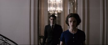 Movie still from “Yves Saint Laurent” (2014), directed by Jalil Lespert – A man and a woman walking down a hall way; Medium shot, Over the shoulder angle