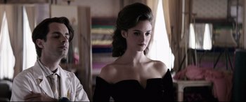 Movie still from “Yves Saint Laurent” (2014), directed by Jalil Lespert – A beautiful young woman in a black dress; Medium shot, Over the shoulder angle