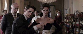 Movie still from “Yves Saint Laurent” (2014), directed by Jalil Lespert – A man and a woman in a black dress; Medium shot, Over the shoulder angle