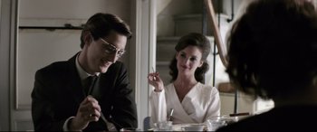 Movie still from “Yves Saint Laurent” (2014), directed by Jalil Lespert – A man and a woman sitting at a dinner table; Medium shot, Over the shoulder angle