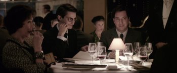 Movie still from “Yves Saint Laurent” (2014), directed by Jalil Lespert – A man and a woman sitting at a dinner table; Medium shot, Over the shoulder angle