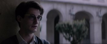 Movie still from “Yves Saint Laurent” (2014), directed by Jalil Lespert – A man with glasses is looking at the camera; Close Up shot, Low angle