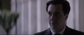 Movie still from “Yves Saint Laurent” (2014), directed by Jalil Lespert – A person wearing a suit and tie; Close Up shot, Low angle