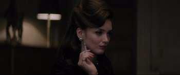 Movie still from “Yves Saint Laurent” (2014), directed by Jalil Lespert – A beautiful woman holding a cell phone up to her ear; Close Up shot, Over the shoulder angle