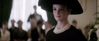 Movie still from “Yves Saint Laurent” (2014), directed by Jalil Lespert – A woman wearing a black hat and pearls; Close Up shot, Low angle