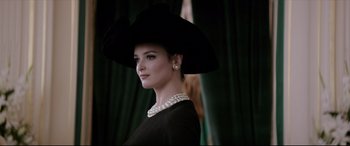 Movie still from “Yves Saint Laurent” (2014), directed by Jalil Lespert – A woman wearing a black hat and a black dress; Close Up shot, Low angle
