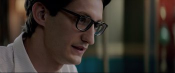 Movie still from “Yves Saint Laurent” (2014), directed by Jalil Lespert – A person wearing glasses; Close Up shot, Over the shoulder angle
