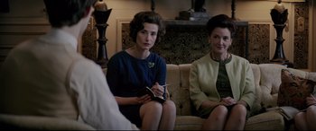 Movie still from “Yves Saint Laurent” (2014), directed by Jalil Lespert – Two women sitting on a couch in a living room; Medium shot, Over the shoulder angle