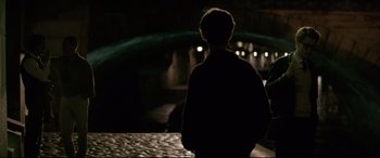 Movie still from “Yves Saint Laurent” (2014), directed by Jalil Lespert – A man standing in the dark looking into the distance; Wide shot, Over the shoulder angle