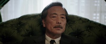 Movie still from “Yves Saint Laurent” (2014), directed by Jalil Lespert – An older man wearing a suit and tie; Close Up shot, Low angle