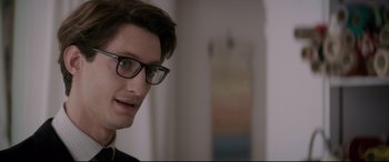 Movie still from “Yves Saint Laurent” (2014), directed by Jalil Lespert – A person wearing glasses; Close Up shot, Over the shoulder angle