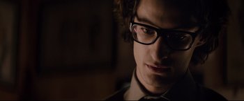 Movie still from “Yves Saint Laurent” (2014), directed by Jalil Lespert – A person wearing glasses; Close Up shot, Over the shoulder angle
