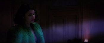 Movie still from “Yves Saint Laurent” (2014), directed by Jalil Lespert – A woman in a green fur coat standing in a room; Medium shot, Over the shoulder angle