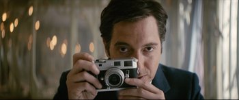 Movie still from “Yves Saint Laurent” (2014), directed by Jalil Lespert – A person taking a picture with a camera; Close Up shot, Low angle