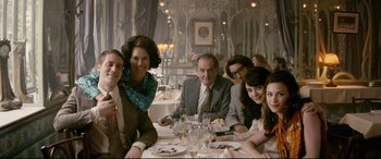 Movie still from “Yves Saint Laurent” (2014), directed by Jalil Lespert – A group of people sitting at a dinner table; Medium shot, High angle