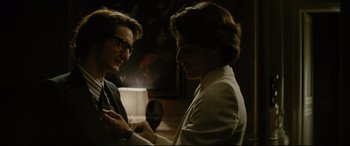 Movie still from “Yves Saint Laurent” (2014), directed by Jalil Lespert – Two men are talking to each other in a dark room; Close Up shot, Over the shoulder angle