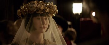 Movie still from “Yves Saint Laurent” (2014), directed by Jalil Lespert – A woman wearing a veil and a flower crown; Close Up shot, Over the shoulder angle