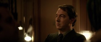 Movie still from “Yves Saint Laurent” (2014), directed by Jalil Lespert – A person wearing a suit and tie; Close Up shot, Low angle