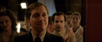 Movie still from “Yves Saint Laurent” (2014), directed by Jalil Lespert – A group of men standing next to each other in a room; Close Up shot, Over the shoulder angle