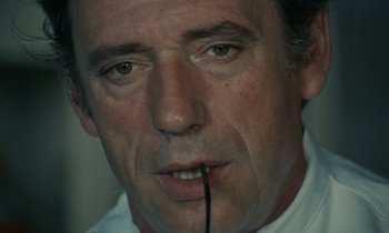 Movie still from “Z” (1969), directed by Costa-Gavras – A person with a stick in his mouth; Extreme Close Up shot, Low angle