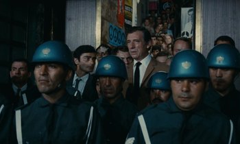 Movie still from “Z” (1969), directed by Costa-Gavras – A group of men standing next to each other wearing helmets; Medium shot, Over the shoulder angle