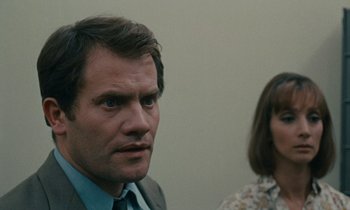 Movie still from “Z” (1969), directed by Costa-Gavras – A man and a woman standing next to each other; Close Up shot, Over the shoulder angle