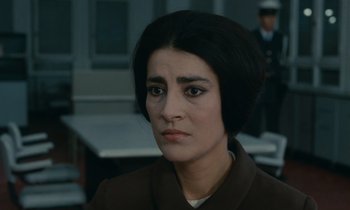 Movie still from “Z” (1969), directed by Costa-Gavras – A person wearing a suit and tie; Close Up shot, Over the shoulder angle