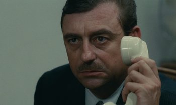 Movie still from “Z” (1969), directed by Costa-Gavras – A person talking on a phone; Close Up shot, High angle