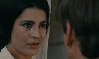 Movie still from “Z” (1969), directed by Costa-Gavras – A person looking at a mirror; Close Up shot, Over the shoulder angle