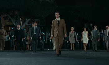 Movie still from “Z” (1969), directed by Costa-Gavras – A group of men and women walking down a street; Wide shot, Low angle