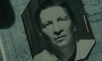 Movie still from “Z” (1969), directed by Costa-Gavras – An old photo of an older man in a white shirt; Extreme Close Up shot, High angle