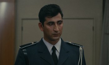 Movie still from “Z” (1969), directed by Costa-Gavras – A man in a uniform is looking at the camera; Close Up shot, Low angle
