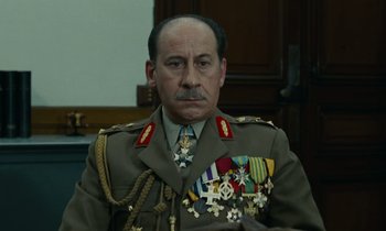 Movie still from “Z” (1969), directed by Costa-Gavras – A person wearing a uniform and medals; Close Up shot, Low angle