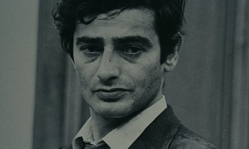 Movie still from “Z” (1969), directed by Costa-Gavras – Black and white photograph of a man in a suit and tie; Close Up shot, High angle