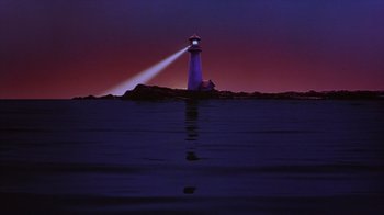 Movie still from “Zero Effect” (1998), directed by Jake Kasdan – A lighthouse is lit up at night on the water; Extreme Wide shot, Low angle