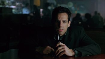 Movie still from “Zero Effect” (1998), directed by Jake Kasdan – A man sitting at a table holding a cell phone; Close Up shot, Low angle