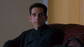 Movie still from “Zero Effect” (1998), directed by Jake Kasdan – A person sitting in a chair wearing a suit; Close Up shot, High angle