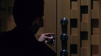 Movie still from “Zero Effect” (1998), directed by Jake Kasdan – A man holding a bunch of keys in front of a door; Extreme Close Up shot, High angle
