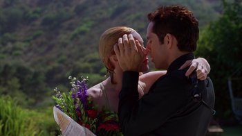 Movie still from “Zero Effect” (1998), directed by Jake Kasdan – A man and a woman kissing each other on the cheek; Close Up shot, Low angle