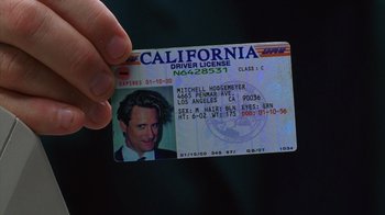 Movie still from “Zero Effect” (1998), directed by Jake Kasdan – A person holding up a california driver's license; Extreme Close Up shot, High angle