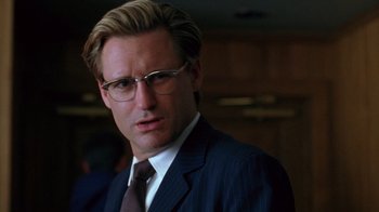 Movie still from “Zero Effect” (1998), directed by Jake Kasdan – A person wearing a suit and glasses; Close Up shot, Low angle