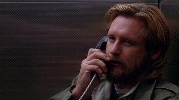 Movie still from “Zero Effect” (1998), directed by Jake Kasdan – A man talking on a phone while sitting in a chair; Close Up shot, Low angle