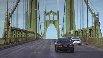 Movie still from “Zero Effect” (1998), directed by Jake Kasdan – Cars driving on a bridge over a large river; Extreme Wide shot, High angle